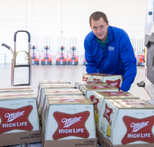 Employee loading Miller High Life cases of beer