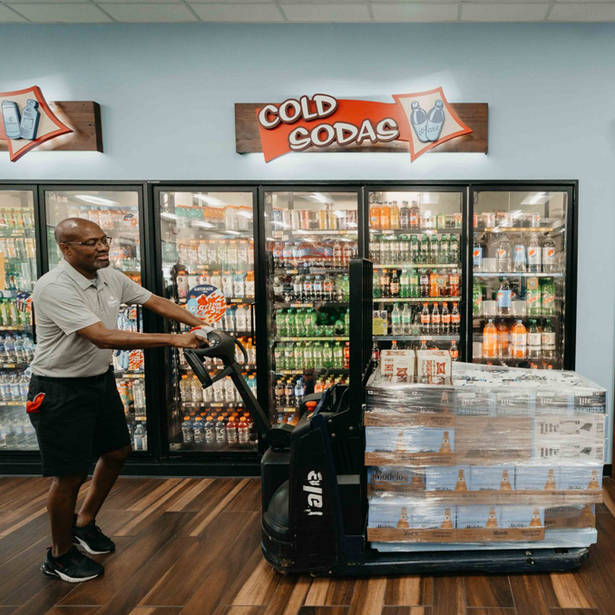 LongBev15_Mobile Employee pushing cases of beer into the beer section of a store