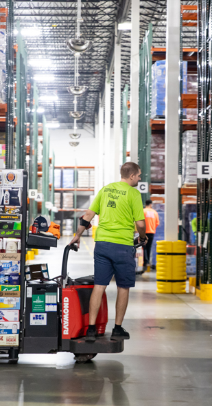Employee moving a huge case of beer and wine at the warehouse